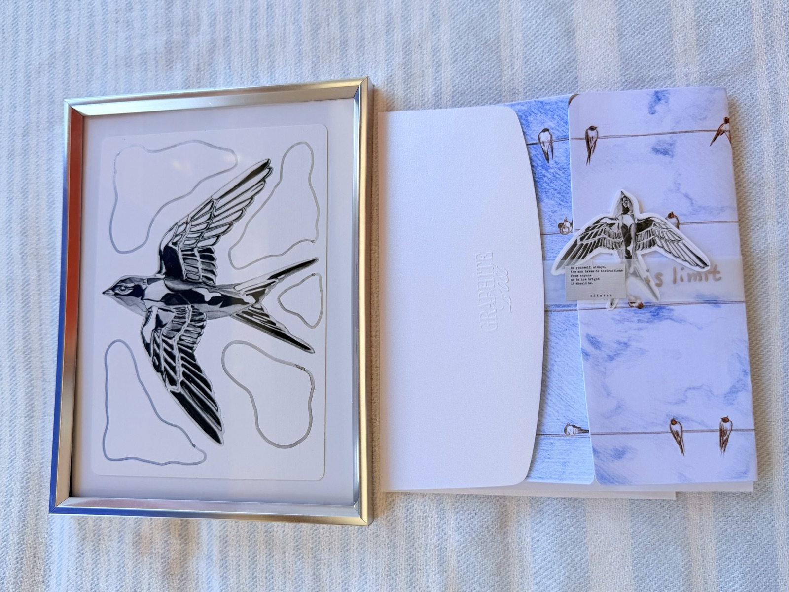Graphite Post swallow collection — framed print, envelope and card spread on table overhead